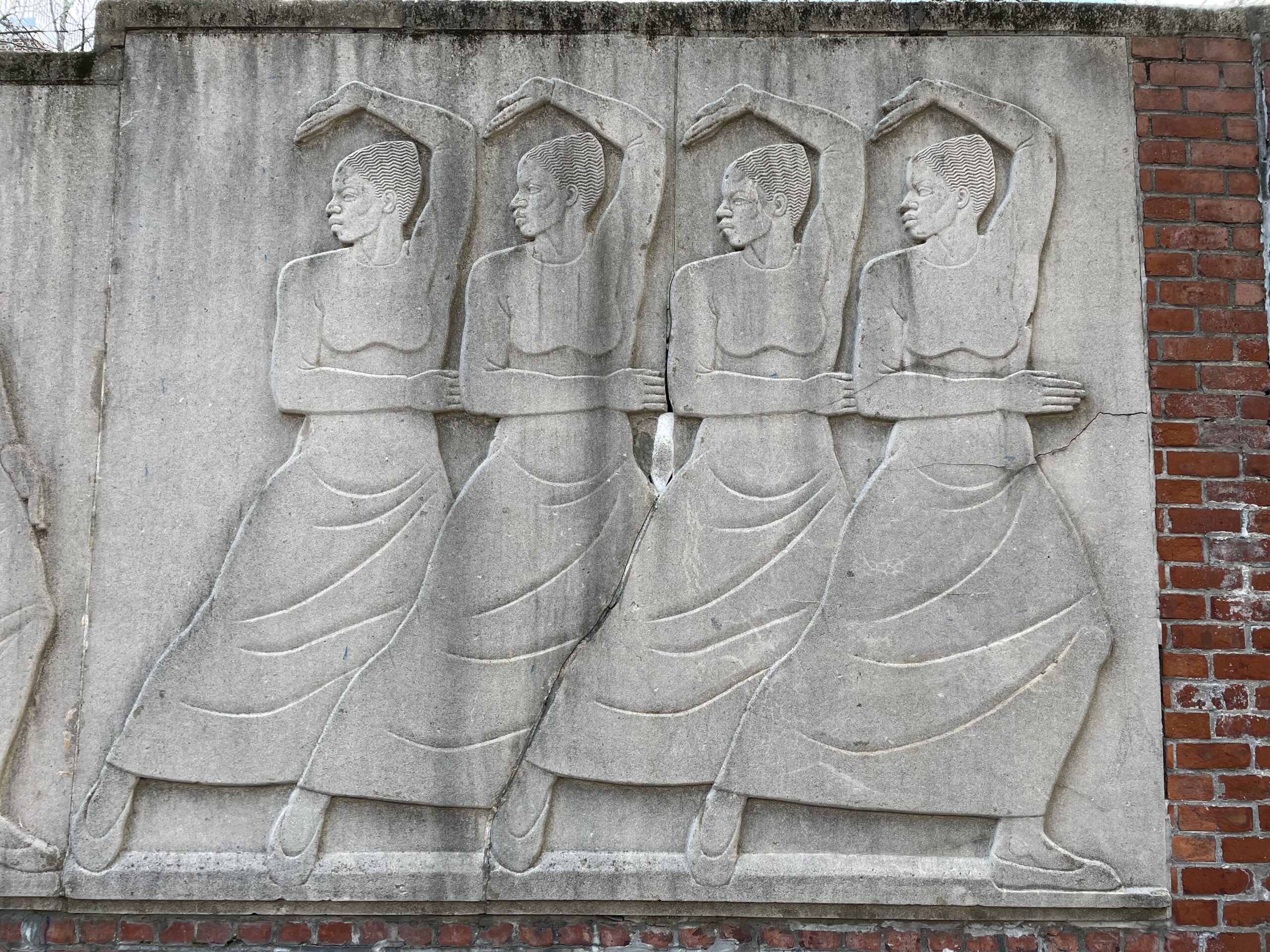 Cement frieze of four dancers in an Art Deco style