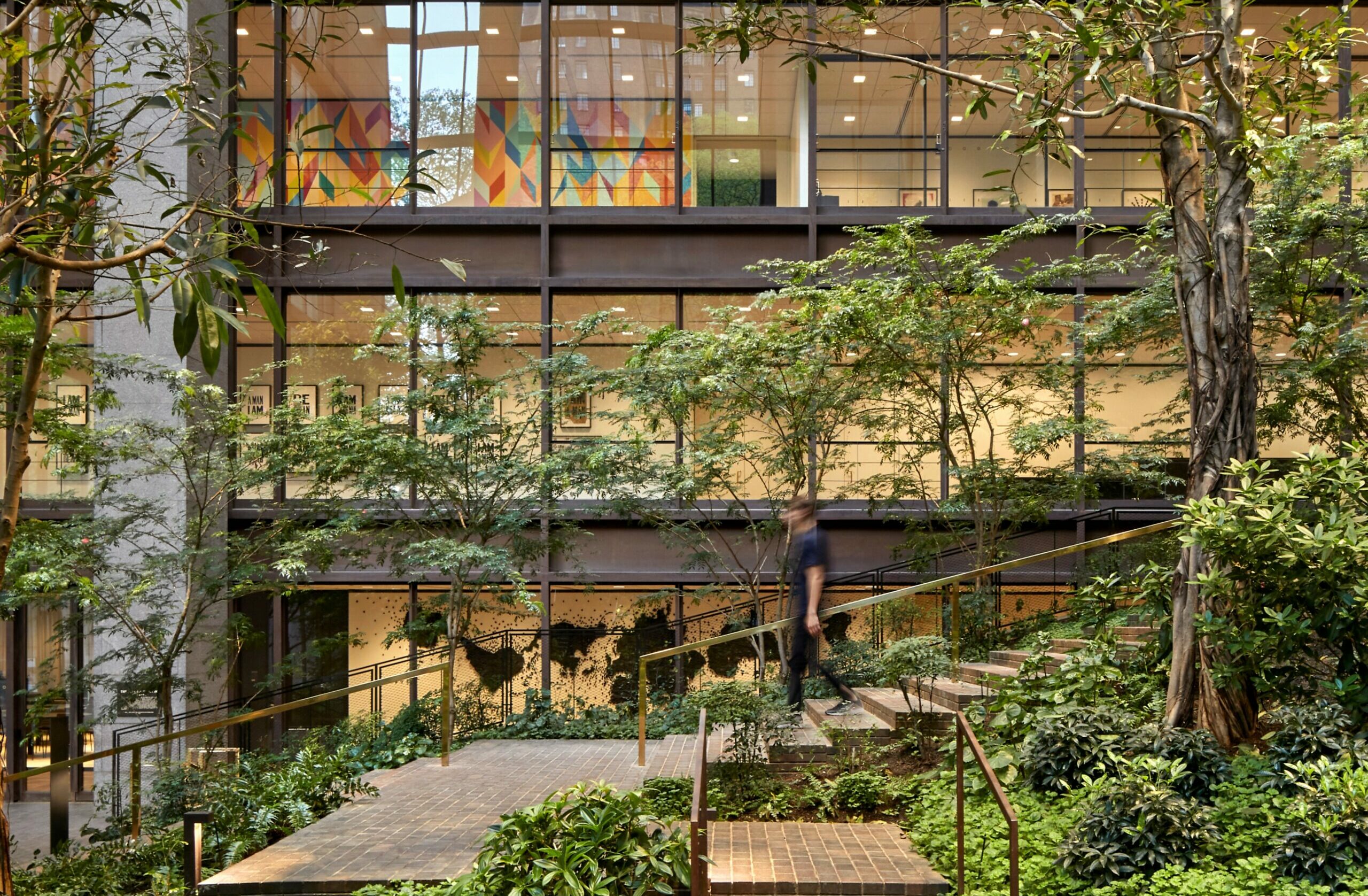 Exterior of the Ford Foundation at night with the Chrysler Building in the background.